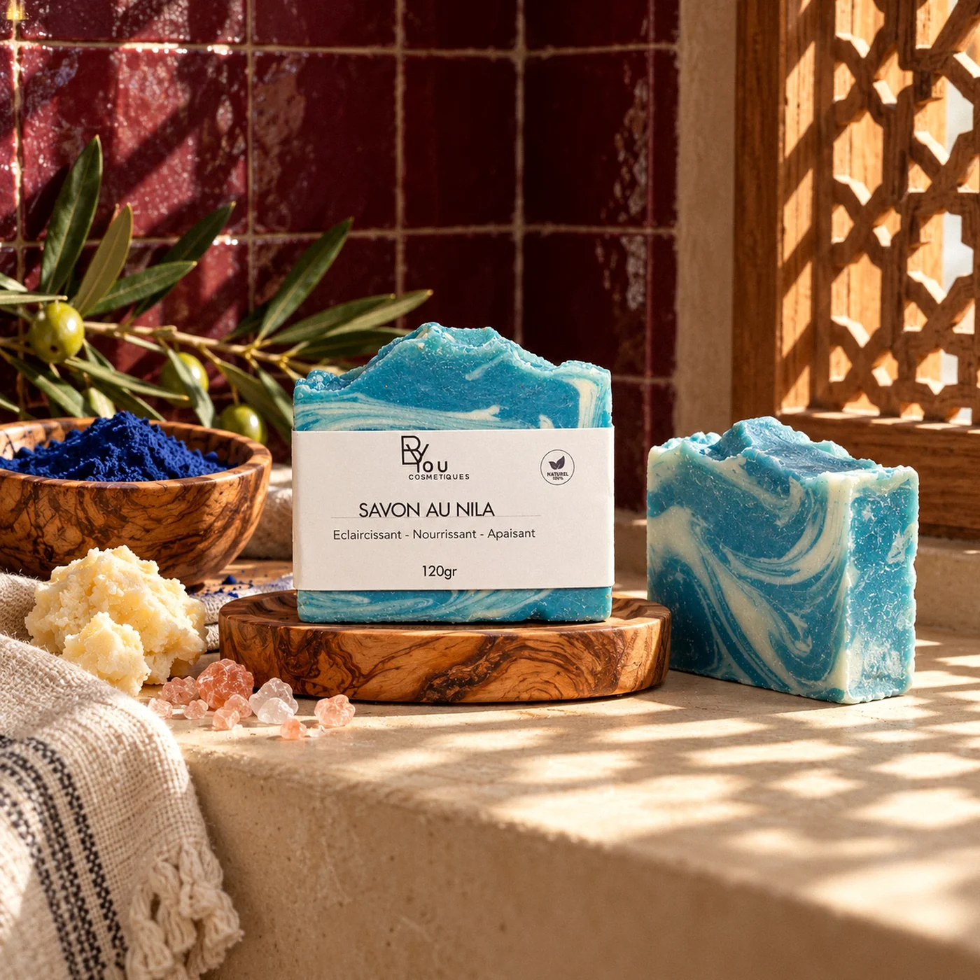 Savon au nila bleu posé sur un porte-savon en bois dans une salle de bain marocaine