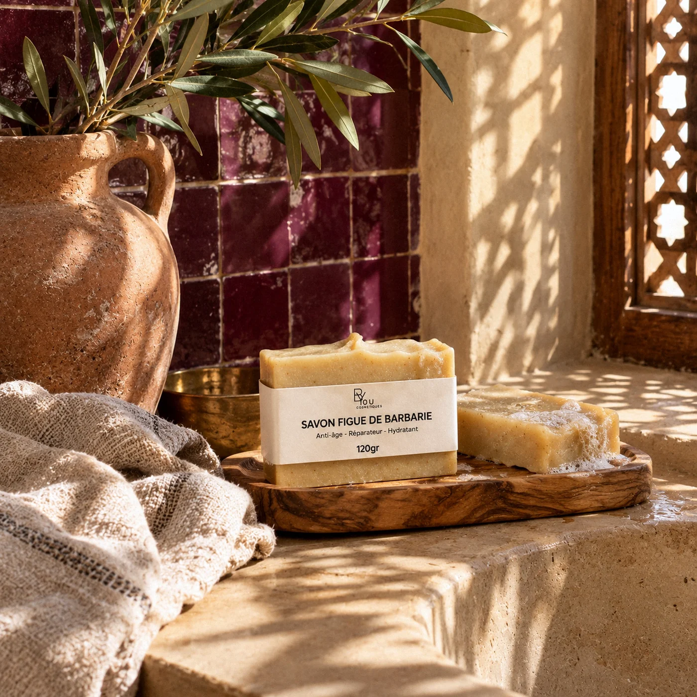 Savon à la figue de barbarie posé sur un porte-savon en bois dans une salle de bain marocaine